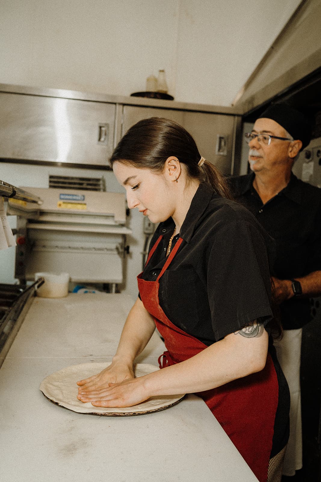 A person shaping pizza dough