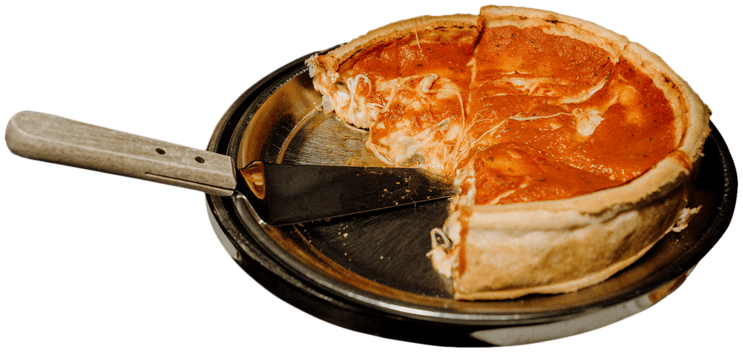 A partially sliced deep-dish pizza sits on a metal tray with a serving spatula.